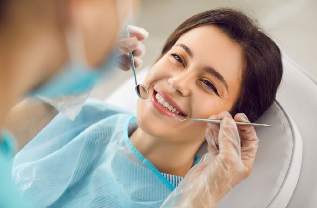 Smiling patient showing restored teeth after receiving a dental implant.